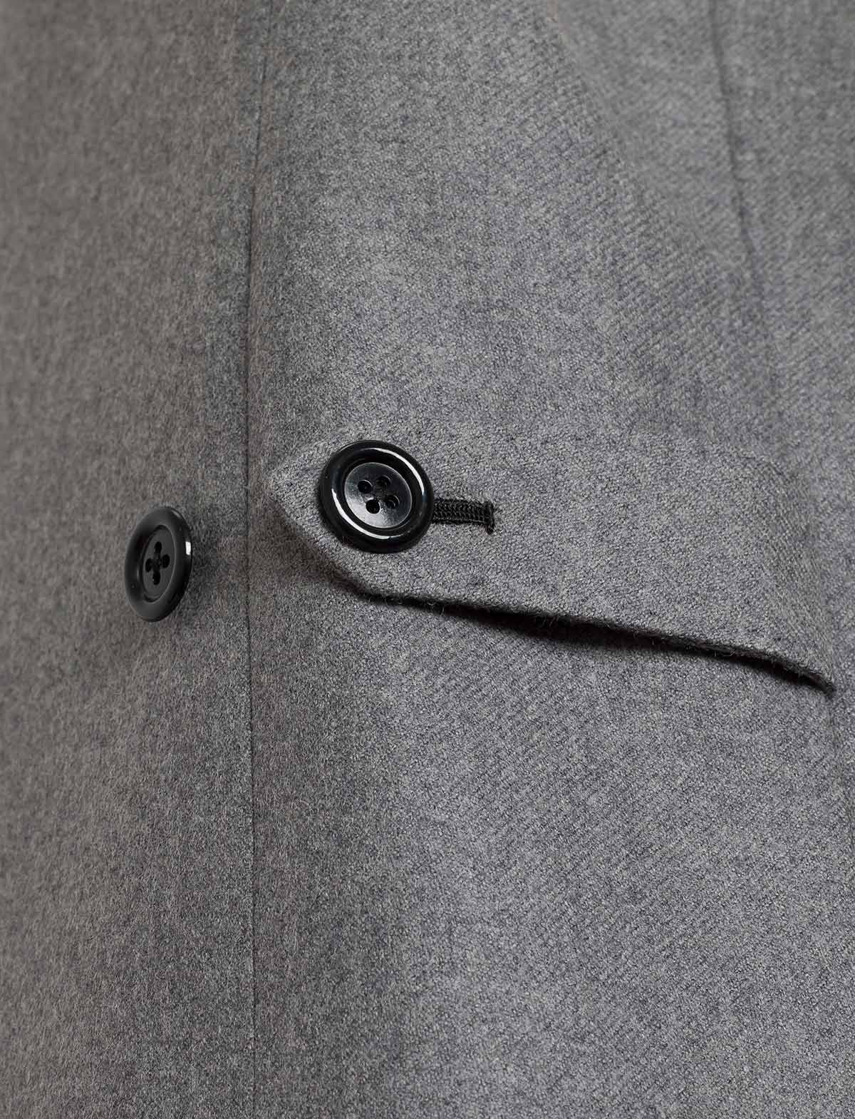 Detalle de cinturillas de chaleco con ojales hechos a mano.