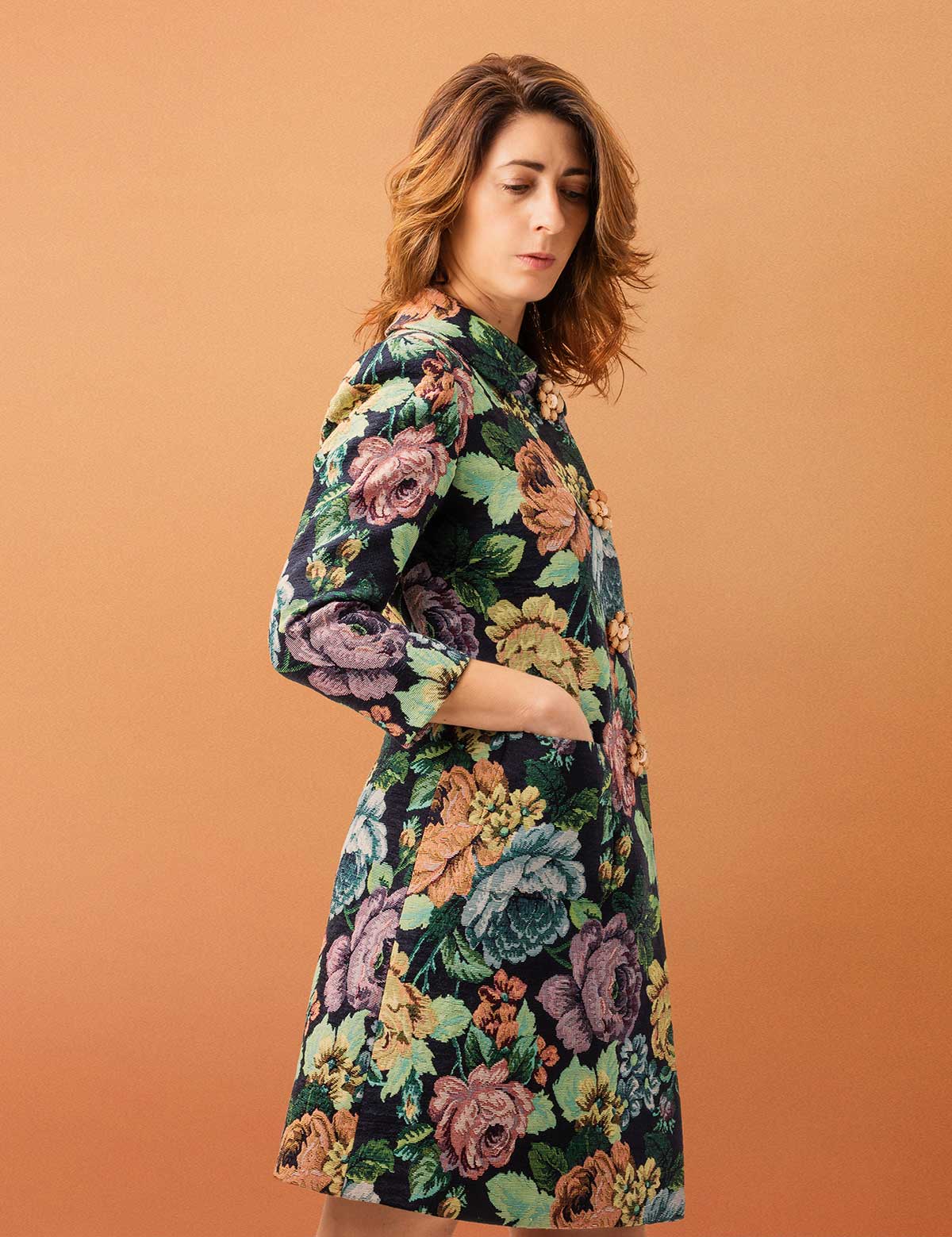 Mujer vistiendo abrigo midi de tela estampada en flores