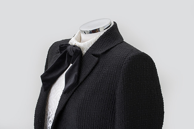 Detalle de cuello de chaqueta de mujer color negro hecha a medida. 