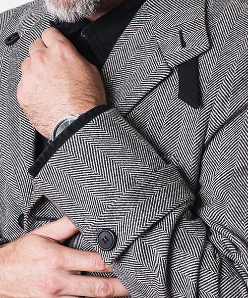 Detalle de manga de abrigo gris de espiga