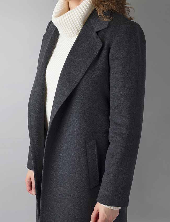 Modelo vistiendo un elegante abrigo gris de mujer hecho a medida. Sastrería Brune.