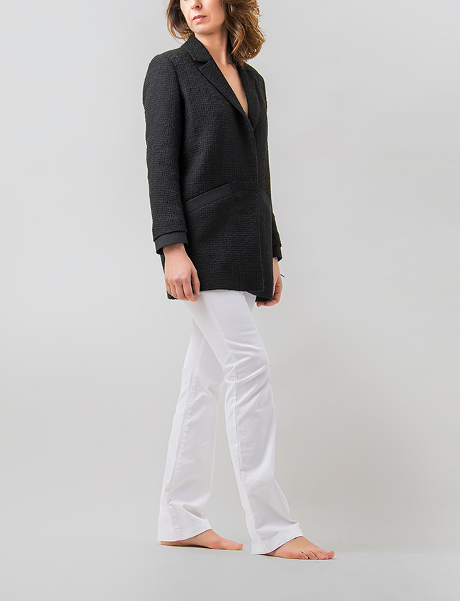 Mujer vistiendo chaqueta oversize color negro en jaquard texturizado. Sastrería Brune. 