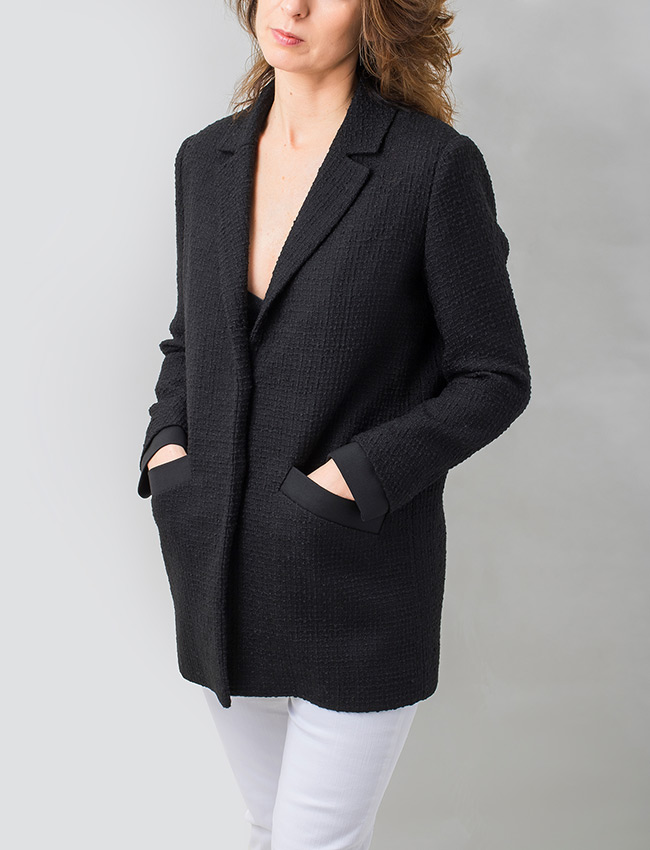 Puños y bolsillos de chaqueta rematados en tejido de raso negro. 