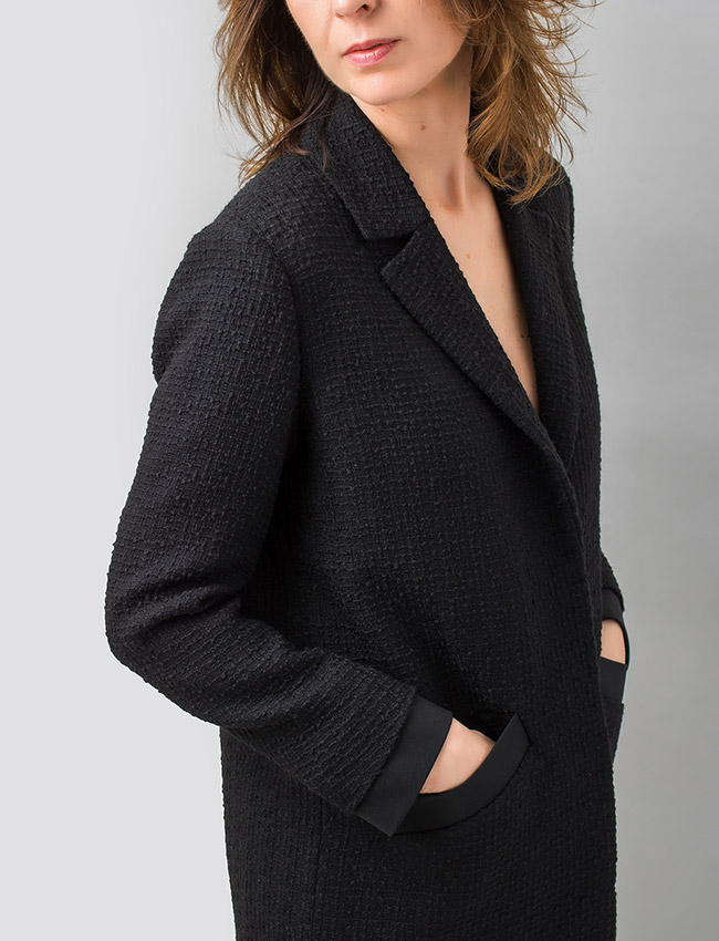 Puños y bolsillos de chaqueta rematados en tejido de raso negro.